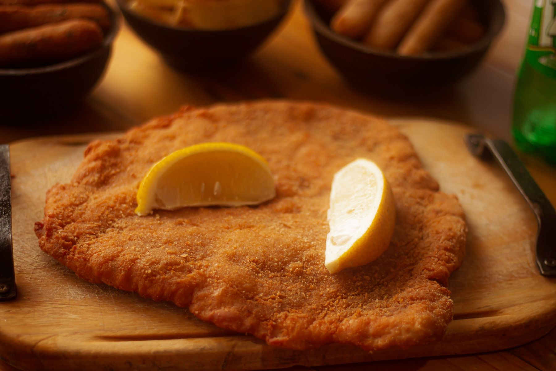 Goldgelbes Schnitzel mit Zitrone auf Holzbrett
