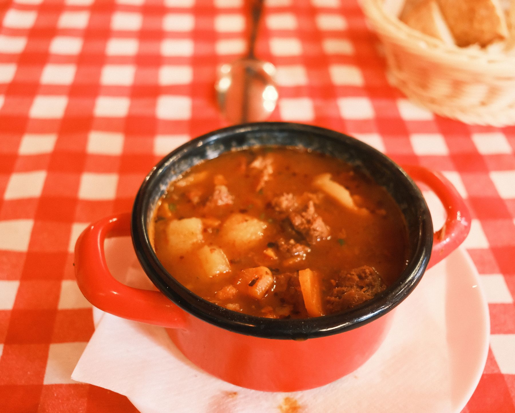 Gulasch im Topf auf kariertem Tischtuch