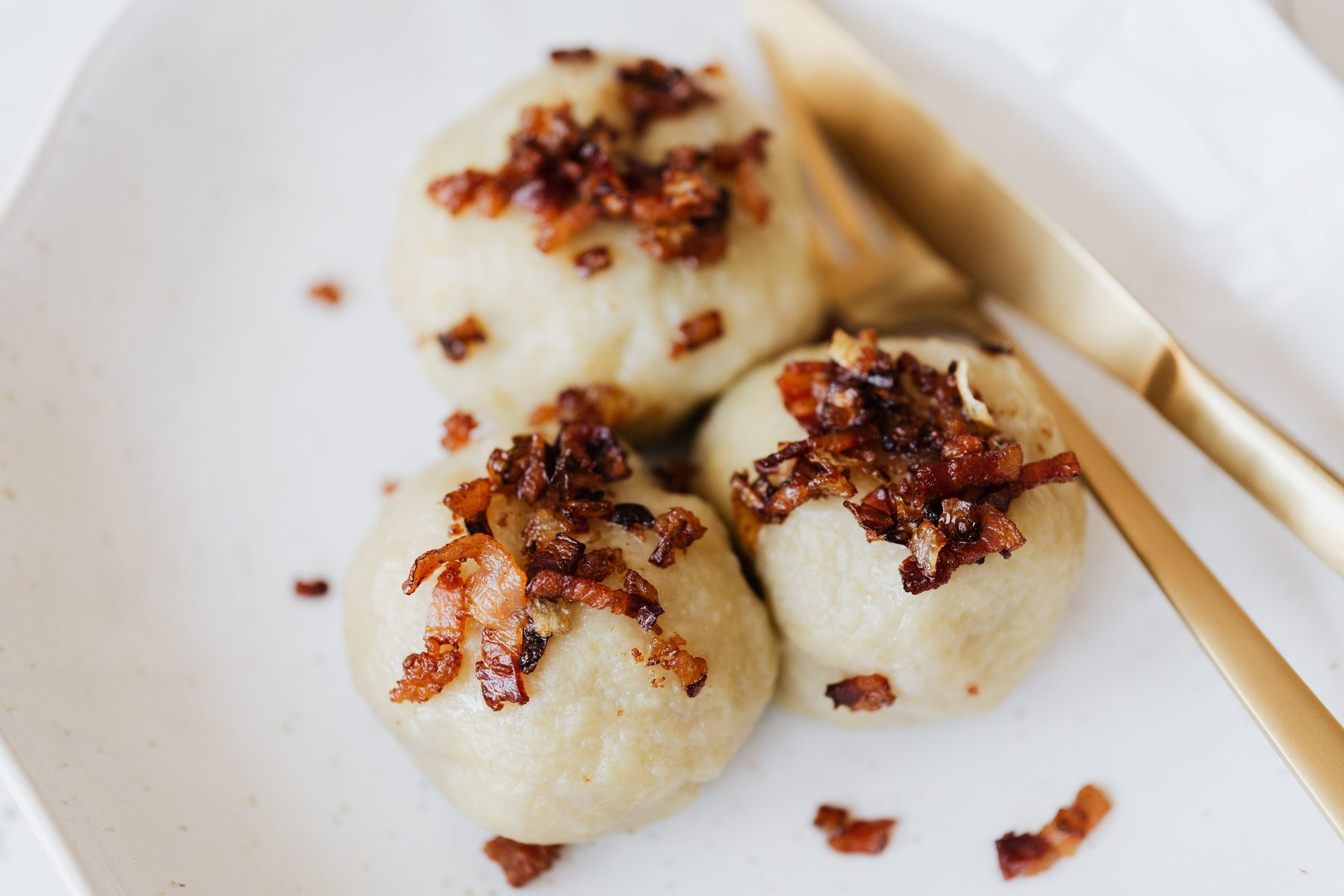 Knödel mit gerösteten Speckwürfeln